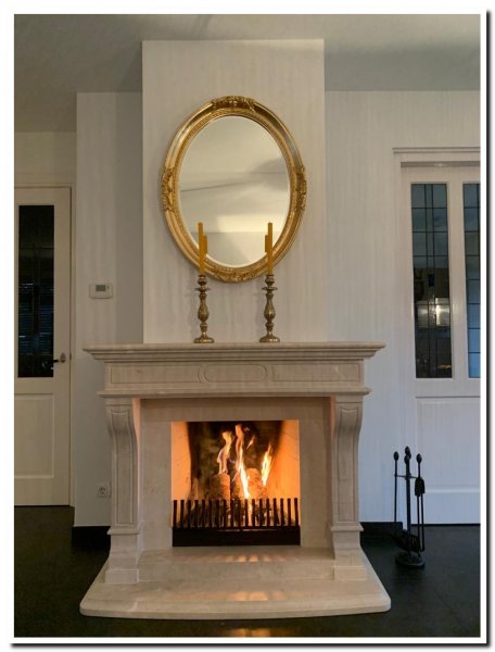 Oval baroque mirror above fireplace